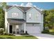 Two-story light green house with a two-car garage at 1010 Lovebug Ln, Summerville, SC 29485