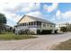 Yellow two-story house with screened porch and stairs leading to entrance at 2302 Palmetto Blvd, Edisto Beach, SC 29438