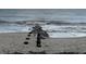 Ocean waves crashing against a beach jetty at 2302 Palmetto Blvd, Edisto Beach, SC 29438