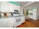 Bright kitchen with white cabinets, wood floors, and modern appliances at 2302 Palmetto Blvd, Edisto Beach, SC 29438