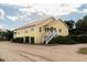 Side view of yellow house with screened porch and white stairs at 2302 Palmetto Blvd, Edisto Beach, SC 29438
