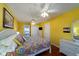 Bedroom with king-size bed, yellow walls, and ceiling fan at 2302 Palmetto Blvd, Edisto Beach, SC 29438