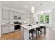 Open concept kitchen with gray cabinets, island seating, and stainless steel appliances at 426 Queenview Ln, Charleston, SC 29414