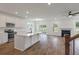 Open concept kitchen with island, hardwood floors, and fireplace in the adjoining room at 135 Ashley Cove Way, Summerville, SC 29483