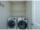 Bright laundry room, features washer, dryer, and overhead shelving at 154 Pecan Dr, Summerville, SC 29483