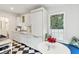 Bright white kitchen with black and white checkered floor, stainless steel appliances and window seat at 74 Vanderhorst St, Charleston, SC 29403