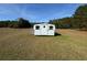 White storage shed in a large grassy area at 204 Charles St, Saint George, SC 29477
