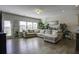 Spacious living room with L-shaped sofa and hardwood floors, access to backyard at 415 Snowy Plover Ln, Summerville, SC 29486