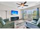 Bright living room featuring two green leather sofas, a large TV, and a ceiling fan at 510 Eastern Isle Ave, Summerville, SC 29486