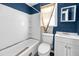 Bathroom with white bathtub, toilet, and vanity; blue walls and worn flooring at 1860/1858 Taberwood Cir, Charleston, SC 29407