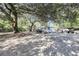 White house with a porch and large trees in the front yard at 1860/1858 Taberwood Cir, Charleston, SC 29407