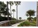 Wooden boardwalk path with palm trees and ocean views at 2588 High Hammock Rd, Johns Island, SC 29455