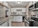 Modern kitchen with white cabinets, granite counters, and stainless steel appliances at 2674 Houston St, North Charleston, SC 29405