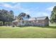 Brick home with metal roof, sunroom addition, and large yard at 203 Hickory Nut Drive, Harleyville, SC 29448
