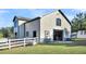 Yellow barn with stalls, white fence, and adjacent shed at 203 Hickory Nut Drive, Harleyville, SC 29448