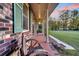 Brick side porch with wooden rocking chairs and green shutters at 203 Hickory Nut Drive, Harleyville, SC 29448