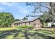 Brick ranch house with a metal roof, nestled on a spacious lot with mature trees at 203 Hickory Nut Drive, Harleyville, SC 29448