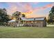 Brick home with sunroom addition, large backyard, and metal roof at 203 Hickory Nut Drive, Harleyville, SC 29448