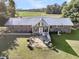 Brick home with metal roof, sunroom, and flagstone patio at 203 Hickory Nut Drive, Harleyville, SC 29448