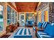 Sunroom with wood ceiling, blue striped sofas, and backyard view at 203 Hickory Nut Drive, Harleyville, SC 29448
