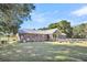 Brick ranch house with metal roof, screened porch, and expansive backyard at 203 Hickory Nut Drive, Harleyville, SC 29448