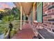 Brick side porch with red tile flooring, green shutters, and a palm tree at 203 Hickory Nut Drive, Harleyville, SC 29448