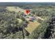 Aerial view showing a house, pond, and surrounding fields at 203 Hickory Nut Drive, Harleyville, SC 29448