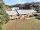 Brick house with metal roof, detached barn, and expansive yard at 203 Hickory Nut Drive, Harleyville, SC 29448