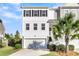 Two-story townhome with white and gray siding, a garage, and a palm tree at 681 Mclernon Trce, Johns Island, SC 29455