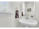 Small bathroom with pedestal sink, mirror, and window with blinds at 681 Mclernon Trce, Johns Island, SC 29455