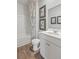 Clean bathroom with a shower/tub combo, white vanity, and wood-look floors at 728 Long Bluff Rd, Summerville, SC 29486