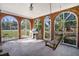 Relaxing screened porch with brick flooring, built-in grill, and wooden swing at 112 Minus St, Saint George, SC 29477