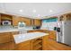 Kitchen features an island with white countertop, stainless steel appliances, and light wood cabinets at 112 Minus St, Saint George, SC 29477