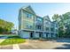 Three-story townhouses with attached garages and green and gray siding at 104 Aplomb Aly # 16, Charleston, SC 29414