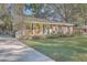 Brick ranch home with covered porch, mature trees, and a spacious yard at 1839 Manigault Pl, Charleston, SC 29407
