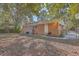 Brick home's backyard features a large grassy area, mature trees, and a grill at 1839 Manigault Pl, Charleston, SC 29407