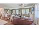 Living room features a sectional sofa, hardwood floors, and a view into dining area at 1839 Manigault Pl, Charleston, SC 29407