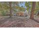 Brick home's backyard with large trees, grassy area, and basketball hoop at 1839 Manigault Pl, Charleston, SC 29407