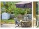 Enjoy your morning coffee on the patio with a view of the storage shed and fenced backyard at 476 Rockville Rd, Moncks Corner, SC 29461