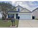 Yellow house with white garage door, green shutters and landscaping at 323 Bradley Bend Dr, Moncks Corner, SC 29461