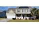 Two-story house with solar panels, porch, and landscaped yard at 1450 Coopers Hawk Dr, Hanahan, SC 29410