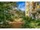 Landscaped path winds through lush greenery towards a yellow building at 4252 Faber Place Dr # 203, North Charleston, SC 29405