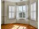 Living room with hardwood floors, bay window, and white shutters at 4252 Faber Place Dr # 203, North Charleston, SC 29405