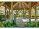 Covered outdoor patio with wooden beams, ceiling fan, and table at 4252 Faber Dr # 203, North Charleston, SC 29405