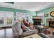 Bright living room with fireplace, hardwood floors, and access to deck at 202 Mary St, Edisto Island, SC 29438