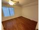 Simple bedroom with wood flooring and large window at 7832 Racquet Rd, North Charleston, SC 29418