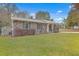 Brick ranch house with a metal roof, landscaping, and a covered porch at 313 Fairlawn Dr, Moncks Corner, SC 29461