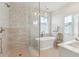 Light and bright bathroom with a soaking tub, glass shower, and marble accents at 9004 Topwater Ln, Johns Island, SC 29455