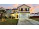Two-story house with a beige exterior, a white garage door, and a well-manicured lawn at 108 Glenspring Dr, Summerville, SC 29486