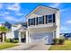 Two-story house with beige siding, black shutters, and a white garage door at 108 Glenspring Dr, Summerville, SC 29486